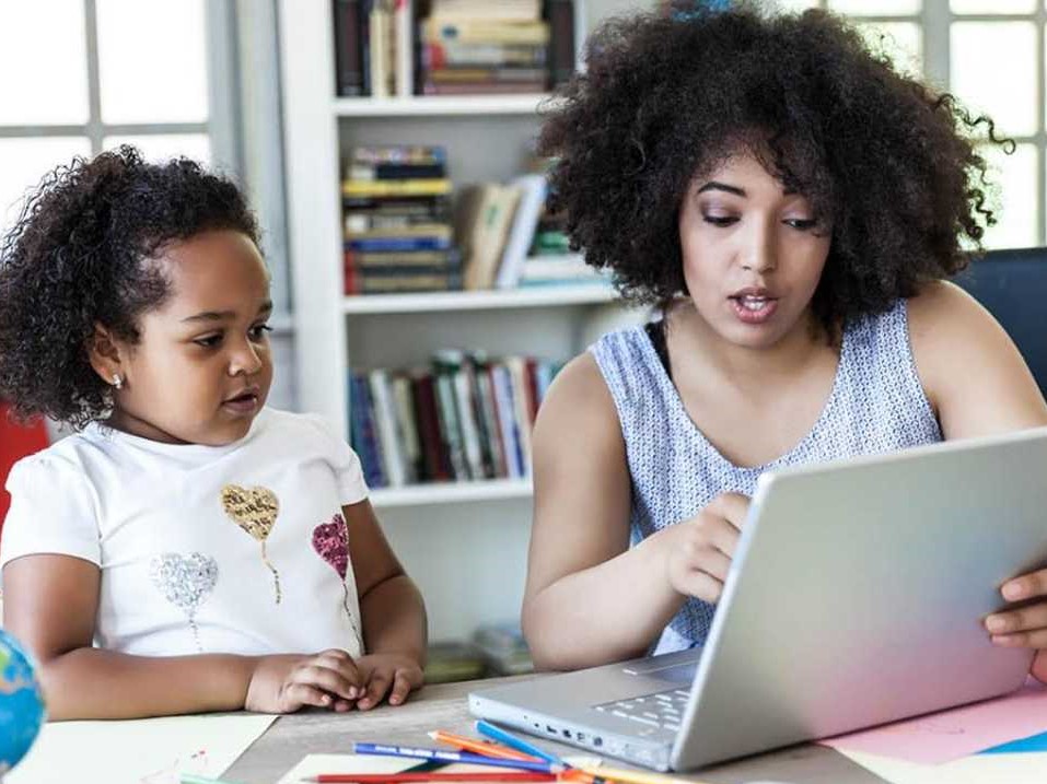 mother helping child at computer